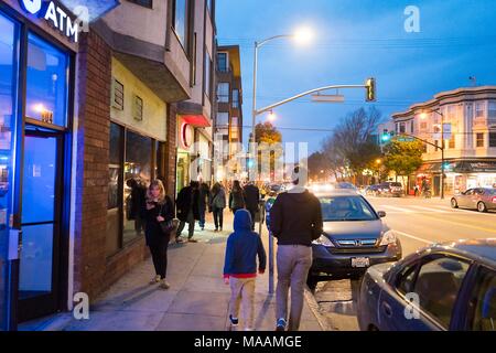 Menschen gehen durch die lebhaften Straßen der Mission District Nachbarschaft in der Dämmerung in San Francisco, Kalifornien, USA, 14. Januar 2018. () Stockfoto