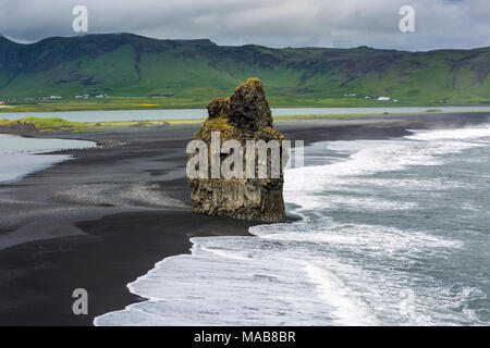 Der schwarze Strand in der Nähe von Vik, Island, Arnardrangur oder "Eagle Rock", Adler es verschachtelte bis 1850, schwarzer Sand Strand Reynisfjara erstellt von der Lava fliesst Stockfoto