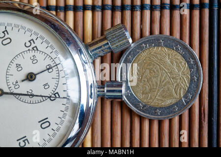 Euro Münze mit einer Stückelung von 2 Euro und die Stoppuhr auf Holztisch - Rückseite Stockfoto
