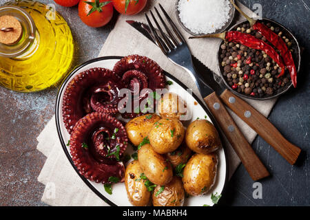 Gegrillter Tintenfisch mit kleinen Kartoffeln mit Kräutern und Gewürzen. Ansicht von oben Stockfoto