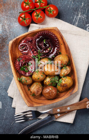 Gegrillter Tintenfisch mit kleinen Kartoffeln mit Kräutern und Gewürzen. Ansicht von oben Stockfoto