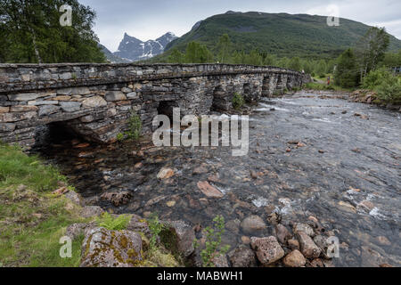 Die Alte Steinbrücke von Honndøla gebaut 1810, in der Nähe von Hellesylt, Norwegen. Die Berge in der Ferne ist Hornindalsrokken, die 5016 Meter erreicht. Stockfoto