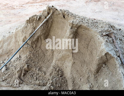 Alte Metall Spaten in den sand haufen für den Einsatz in der Baustelle. Stockfoto