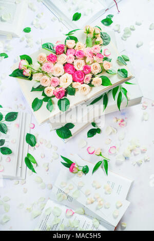 Stapel von weißen Bücher mit Blumen und Blüten. Feder lesen Konzept. Feminine noch Leben in high key mit kopieren. Stockfoto