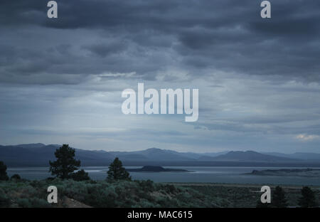 Sturm in über eine kalte einsame Landschaft mit See und ein paar Sonnenstrahlen durch die Wolken Stockfoto