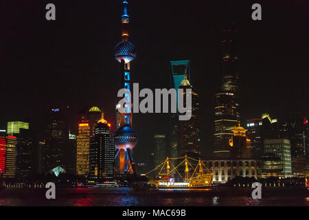 Nacht Blick auf die Skyline von Pudong und Boot auf den Fluss Huangpu, Shanghai, China Stockfoto