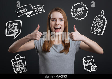 Person ihre Daumen, aufgeregt, während er über einen großen Verkauf Stockfoto