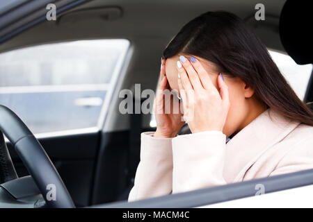 Junge gedrückt Frau Fahrer mit Kopf in den Händen Stockfoto