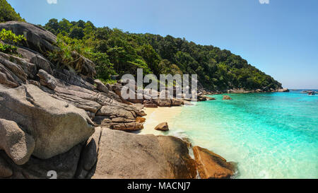 Panorama der unberührten leeren Strand der Similan Inseln mit idyllischen riesigen Felsen, Sonne, Urwald Wald und türkis grün blau Meer an sonnigen Tag genommen. Pha Stockfoto