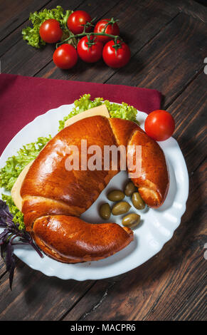 Vollkornbrot Bagel mit grünem Pesto, frisches Gemüse, Käse, Tomaten auf einem alten Holztisch. Stockfoto