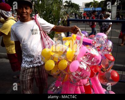 ANTIPOLO CITY, Philippinen - 29. MÄRZ 2018: einem Straßenhändler verkauft Bunte aufblasbare Spielzeuge. Stockfoto