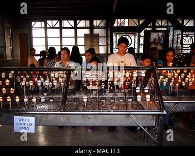 ANTIPOLO CITY, Philippinen - 29. MÄRZ 2018: die katholischen Gläubigen beten und Gebet Kerzen in Antipolo Kathedrale oder Unsere Liebe Frau des Friedens und sichere Voyag Stockfoto