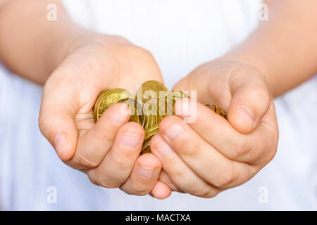 Ein paar kleine Münzen in den Händen eines kleinen Jungen. Kind spart Geld. Geld aus der Tschechischen Republik. Stockfoto