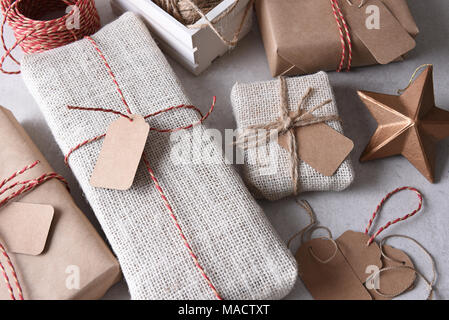 Verpackung Weihnachtsgeschenke. High Angle Shot einer Gruppe von Stoff und Papier eingewickelt präsentiert. Stockfoto