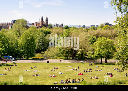 Jugendliche, Studenten der Universität von Glasgow mit einem warmen sonnigen Tag auf dem Rasen des Kelvingrove Park, Kelvingrove Art Gallery und Museum in Stockfoto