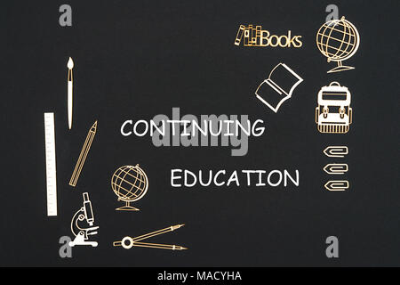Schulbedarf Spanplatte Miniaturen auf Tafel platziert mit Text Weiterbildung. Konzept Bildung Schule Stockfoto