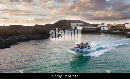 23.12.2017: Boot mit Touristen auf der Pier der Insel Lobos, vor der Küste von Corralejo, auf der Insel Fuerteventura Stockfoto