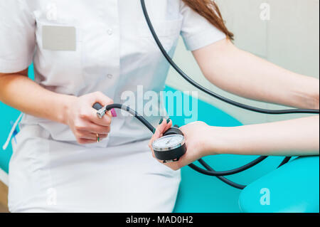 Nahaufnahme der weiblichen Medizin Arzt Blutdruck messen zu ihrer Patienten. Die Hände schließen. Gesundheitswesen, gesunde Lebensweise und medizinische Service Konzept Stockfoto