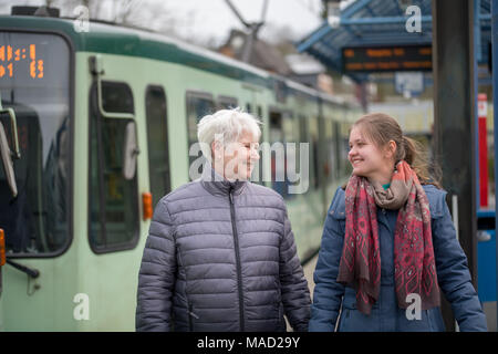 Zwei Frauen, alt und jung, Spaziergang an der Haltestelle Stockfoto