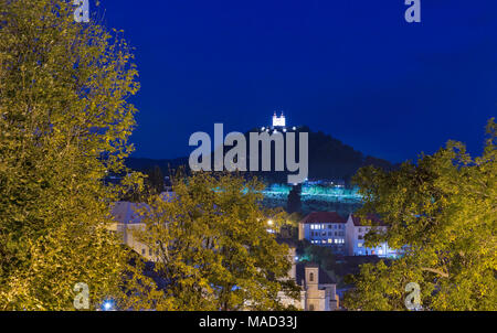 Nacht Stadtbild mit alten Häusern in der Altstadt und dem Kalvarienberg auf der Spitze des Hügels in Banska Stiavnica, Slowakei Stockfoto