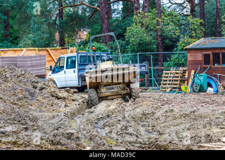 Dumper und weißen Van auf einem Schlammigen aufgewühlten bis Wohnungsbau Website in Surrey im Südosten Englands in feuchten, schlechtes Wetter Stockfoto