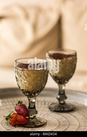 Zwei Tassen tiramisu im eleganten Glas und Erdbeere am Metallfach aus. Vertikale Komposition. Stockfoto