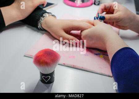 Maniküre Nagel Lack, Closeup Schoß einer Frau in einem Nagelstudio, Maniküre, von einer Kosmetikerin Stockfoto