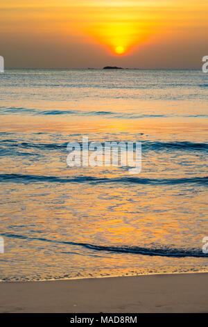 Die Sonne über Pigeon Island National Park aus Nilavelli Strand in Trincomalee, Sri Lanka. Stockfoto