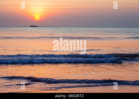 Die Sonne über Pigeon Island National Park aus Nilavelli Strand in Trincomalee, Sri Lanka. Stockfoto