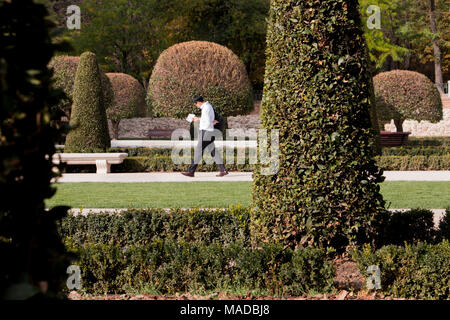 Mann Lesen und Wandern im Parque de El Retiro, zentral, Madrid, Spanien Stockfoto