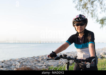 Freudige senior Frau mit dem Fahrrad Stockfoto