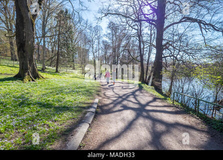 Nicht erkennbare Personen genießen Sie einen Spaziergang und die Atmosphäre in der Stadt Park entlang Fluss Motala in Norrköping. . Stockfoto