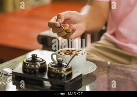 Nahaufnahme eines 7/8-man Zucker in Kaffee Tasse gießen Stockfoto