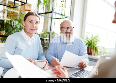 Senior paar Diskussion über finanzielle Dokumente mit Agent vor der Unterzeichnung Stockfoto