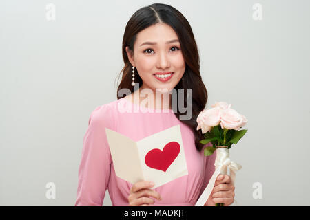 Schöne asiatische Mädchen liest Liebesbrief. Glückliche Frau Tag. Stockfoto