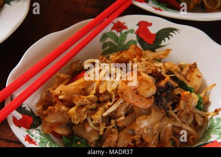 Gebratene Kway Teow, einer beliebten Straße Futternapf von gebratenen Flachbild Reis Nudeln mit Meeresfrüchten, Gemüse und Sojasauce in Medan, North Sumatra. Stockfoto