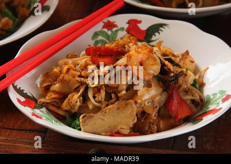 Gebratene Kway Teow, einer beliebten Straße Futternapf von gebratenen Flachbild Reis Nudeln mit Meeresfrüchten, Gemüse und Sojasauce in Medan, North Sumatra. Stockfoto