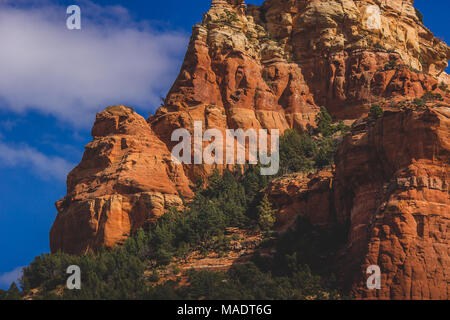 Detaillierte Ansicht des Capitol Butte (aka Thunder Mountain) Red Rock Formation aus Dry Creek Vista an einem sonnigen Tag mit blauen Himmel und Wolken, Sedona, Arizona Stockfoto