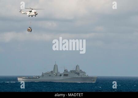 180328-N-DL 434-068 philippinischen Meer (29. März 2018) Die amphibious Transport dock Schiff USS Green Bay (LPD 20) dampft durch den philippinischen Meer als SA-330 Puma Helikopter, zugeordnet zu den Dry Cargo und Munition ship USNS Wally Schirra (T-AKE 8), Transporte, Lieferungen während einer Auffüllung-auf-See mit dem Wasp Expeditionary Strike Group (ESG). Green Bay, als Teil der Wasp ESG, im Indo-pazifischen Region als Teil einer regelmäßigen Patrouillen- und bietet eine schnelle Reaktionsfähigkeit im Falle eines regionalen Kontingenz oder Naturkatastrophen. (U.S. Marine Foto von Masse Communicati Stockfoto