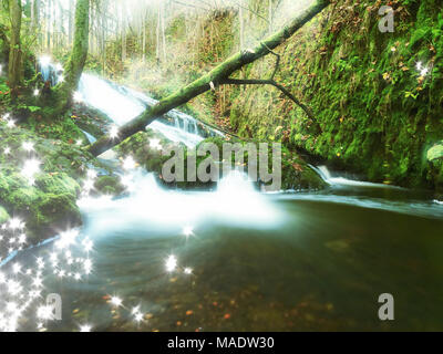 Abstrakte Wirkung. Stromschnellen auf kleinen Gebirgsbach zwischen moosbewachsenen Basaltfelsen. Fließend Wasser Wellen laufen über Steine, bunte Blätter an Banken. Hohe Stockfoto
