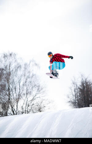 Bild der Athlet im Helm reiten Snowboard aus Schnee Hang im Winter Stockfoto