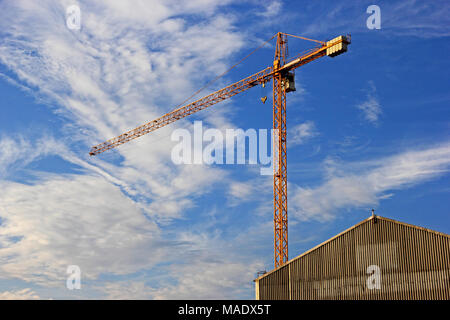 Kran überragt die Gebäude gegen bewölkt blauer Himmel Stockfoto