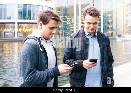Zwei Handy süchtig männliche Jugendliche gemeinsam am Smartphone suchen Stockfoto