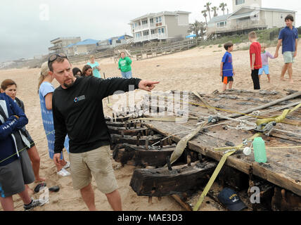 März 30, 2018-Ponte Vedra Beach, Florida, United States - Archäologe Brendan Burke beantwortet Fragen von Neugierigen über ein Schiffswrack, das am 28. März 2018 nach dem Landgang aus Ponte Vedra Beach in Florida gewaschen entdeckt wurde. Ein Team aus der St. Augustine Leuchtturm archäologische Maritime Programm ist der Prüfung und Messung der 48-Fuß-langen hölzernen Überreste, die geglaubt werden, um Teil einer Handelsschiff, dass Ladung entlang der Atlantikküste der USA während Anfang bis Mitte der 1800er Jahren transportiert werden. (Paul Hennessy/Alamy) Stockfoto