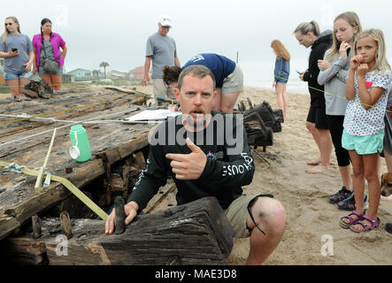 März 30, 2018-Ponte Vedra Beach, Florida, United States - Archäologe Brendan Burke beantwortet Fragen über ein Schiffswrack, das am 28. März 2018 nach dem Landgang aus Ponte Vedra Beach in Florida gewaschen entdeckt wurde. Ein Team aus der St. Augustine Leuchtturm archäologische Maritime Programm ist der Prüfung und Messung der 48-Fuß-langen hölzernen Überreste, die geglaubt werden, um Teil einer Handelsschiff, dass Ladung entlang der Atlantikküste der USA während Anfang bis Mitte der 1800er Jahren transportiert werden. (Paul Hennessy/Alamy) Stockfoto