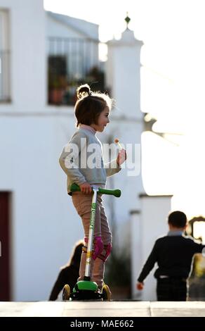 Andalusien, Andalusien. 31 Mär, 2018. Ein Mädchen spielt Roller auf der Straße von Cazalla de la Sierra, Andalusien, Spanien am 31. März 2018. Jeder genießt ihr Leben im Freien als Feder in Cazalla de la Sierra, eine kleine schöne spanische Stadt kommt. Quelle: Guo Qiuda/Xinhua/Alamy leben Nachrichten Stockfoto
