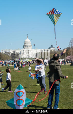 Die Menschen genießen Sie bei schönem Wetter auf der jährlichen Smithsonian Kite Festival Festival in Washington DC mit dem Kapitol Gebäude im Hintergrund. Foto Datum: Samstag, 31. März 2018. Foto: Roger Garfield/Alamy Stockfoto