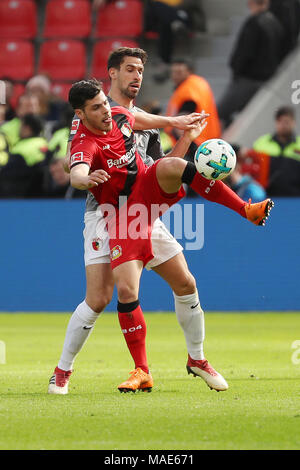 Leverkusen. 31 Mär, 2018. Kevin Volland (R) von Bayer 04 Leverkusen Mias mit Rani Khedira des FC Augsburg bei dem Bundesligaspiel zwischen Bayer 04 Leverkusen und FC Augsburg in der BayArena am 31. März 2018 in Leverkusen, Deutschland. Das Spiel endete mit einem 0:0-Unentschieden. Credit: Ulrich Hufnagel/Xinhua/Alamy leben Nachrichten Stockfoto