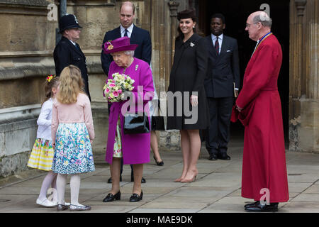 Windsor, Großbritannien. Der 1. April 2018. Madeleine Carleston und Amelia Vivian, beide im Alter von 6, geben die traditionellen posies von Blumen an die Königin, als sie den Ostersonntag Service in der St. George's Chapel in Windsor Castle verlässt. Credit: Mark Kerrison/Alamy leben Nachrichten Stockfoto