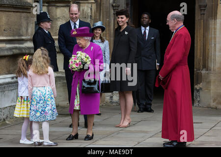 Windsor, Großbritannien. Der 1. April 2018. Madeleine Carleston und Amelia Vivian, beide im Alter von 6, geben die traditionellen posies von Blumen an die Königin, als sie den Ostersonntag Service in der St. George's Chapel in Windsor Castle verlässt. Credit: Mark Kerrison/Alamy leben Nachrichten Stockfoto